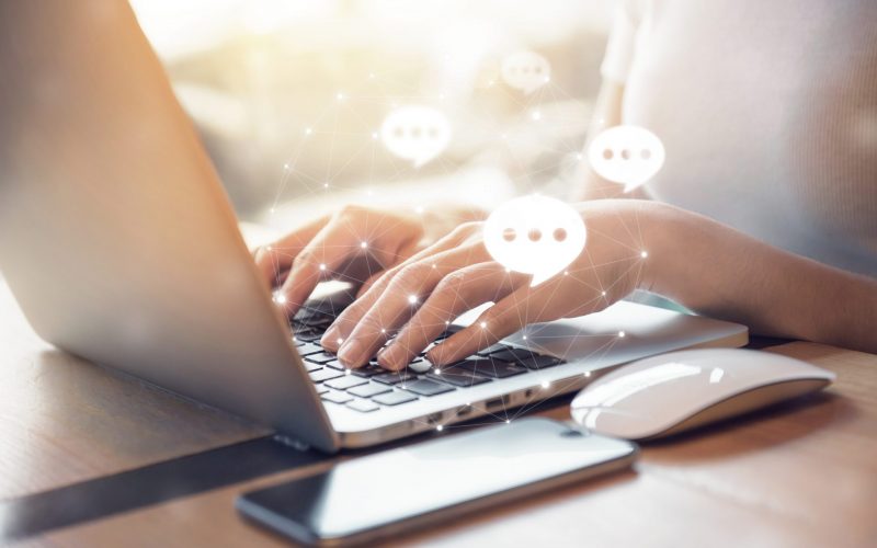 women's hand typing on keyboard laptop with mobile smartphone,Live Chat Chatting on application Communication Digital Web and social network Concept